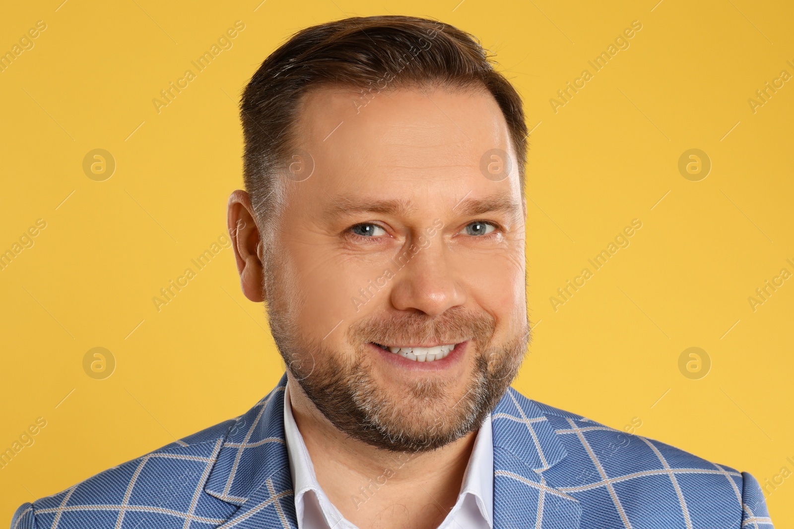 Photo of Portrait of happy mature man on yellow background