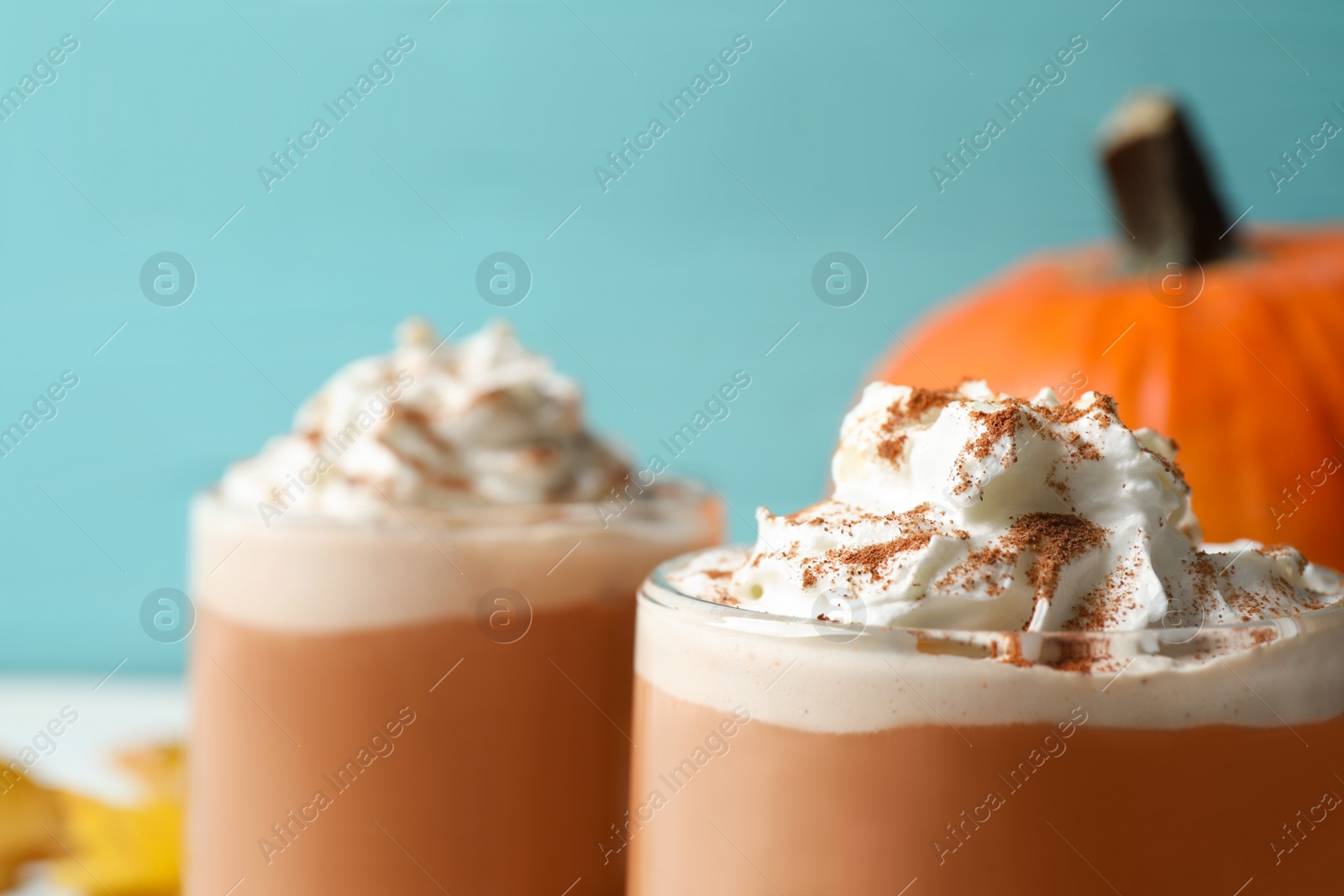 Photo of Delicious pumpkin latte with whipped cream on table, closeup