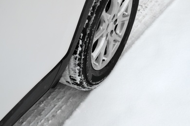 Photo of Modern car on snowy road, closeup view. Winter season