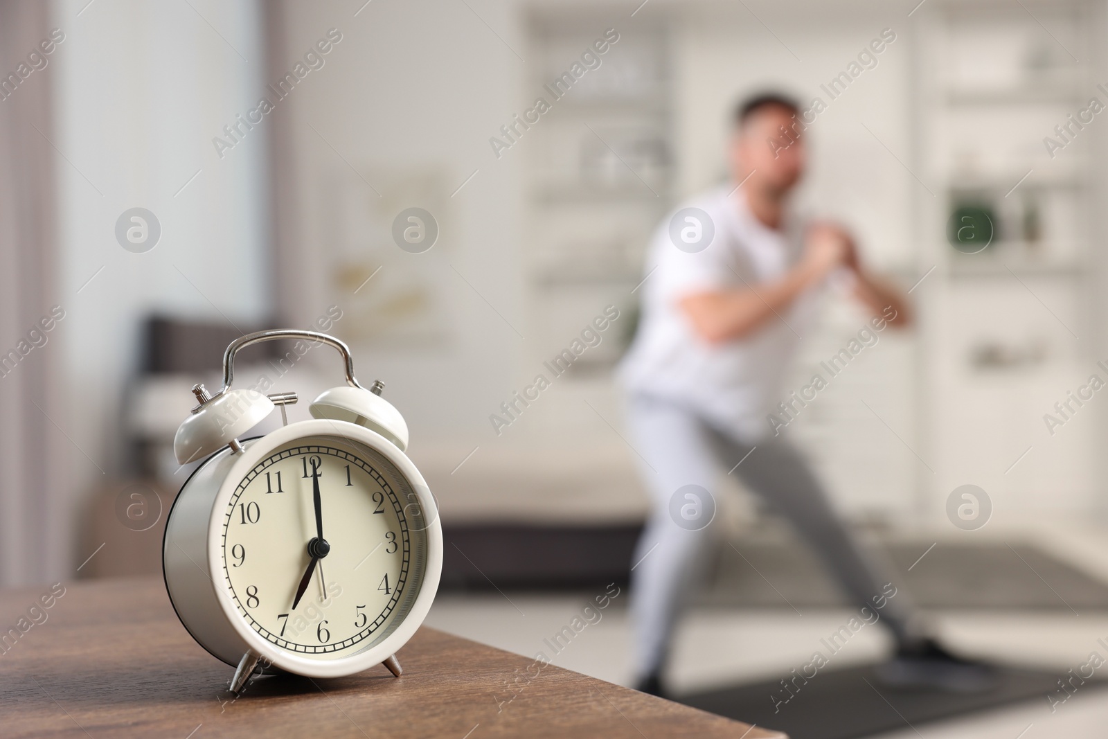 Photo of Man doing morning exercise on fitness mat at home, selective focus. Space for text