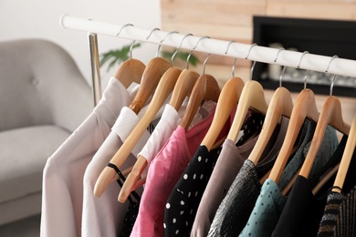 Wardrobe rack with stylish clothes indoors, closeup