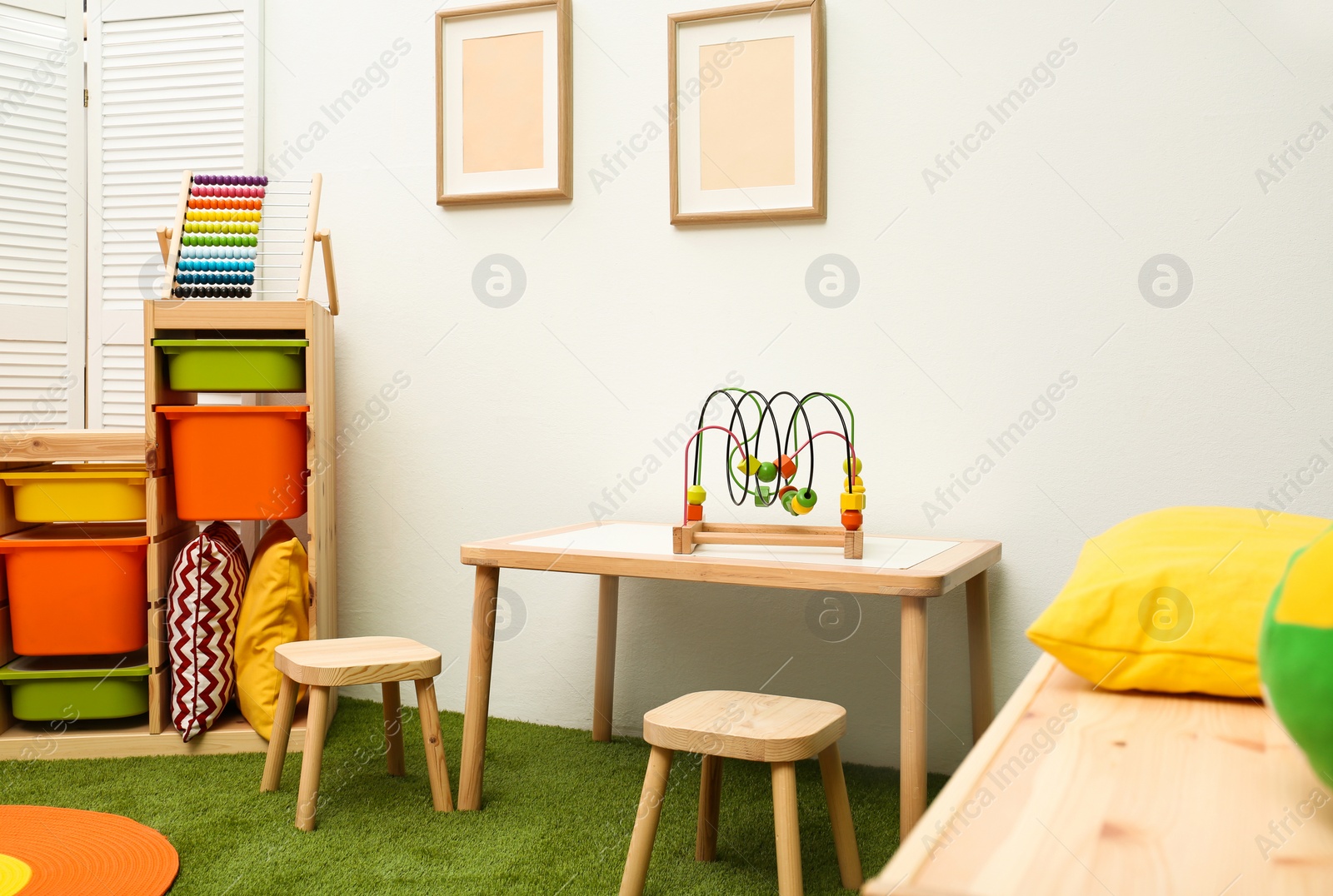 Photo of Stylish playroom interior with table and stools