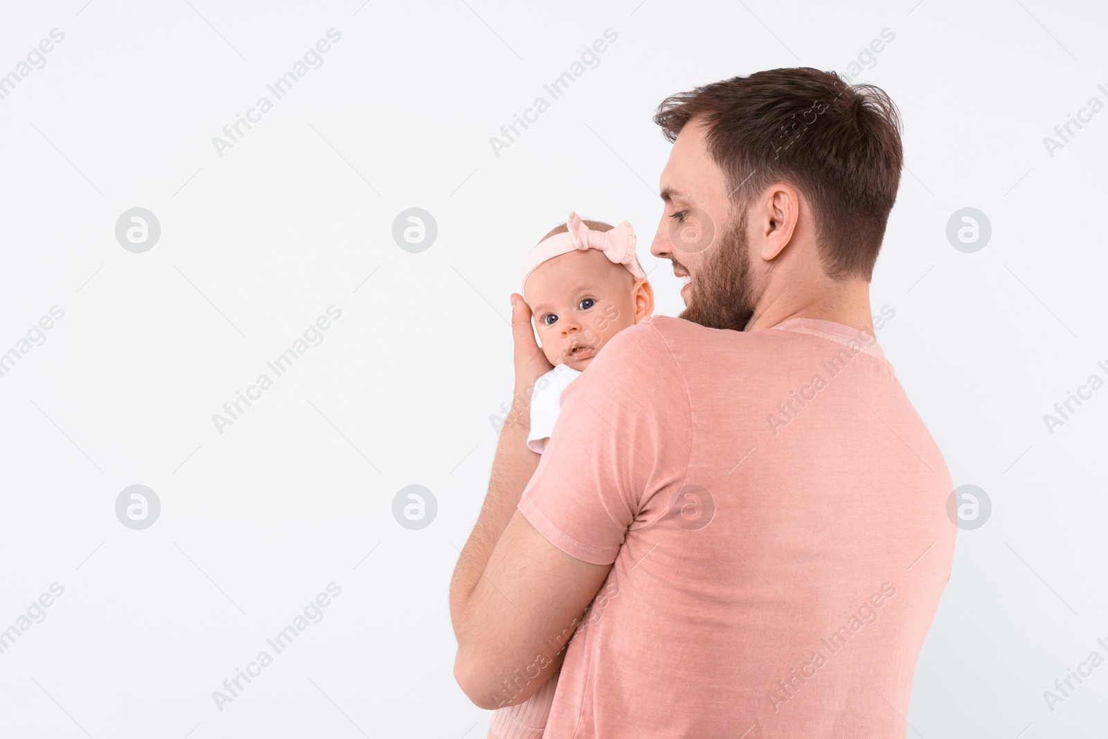 Photo of Happy father with his cute baby on light background, space for text