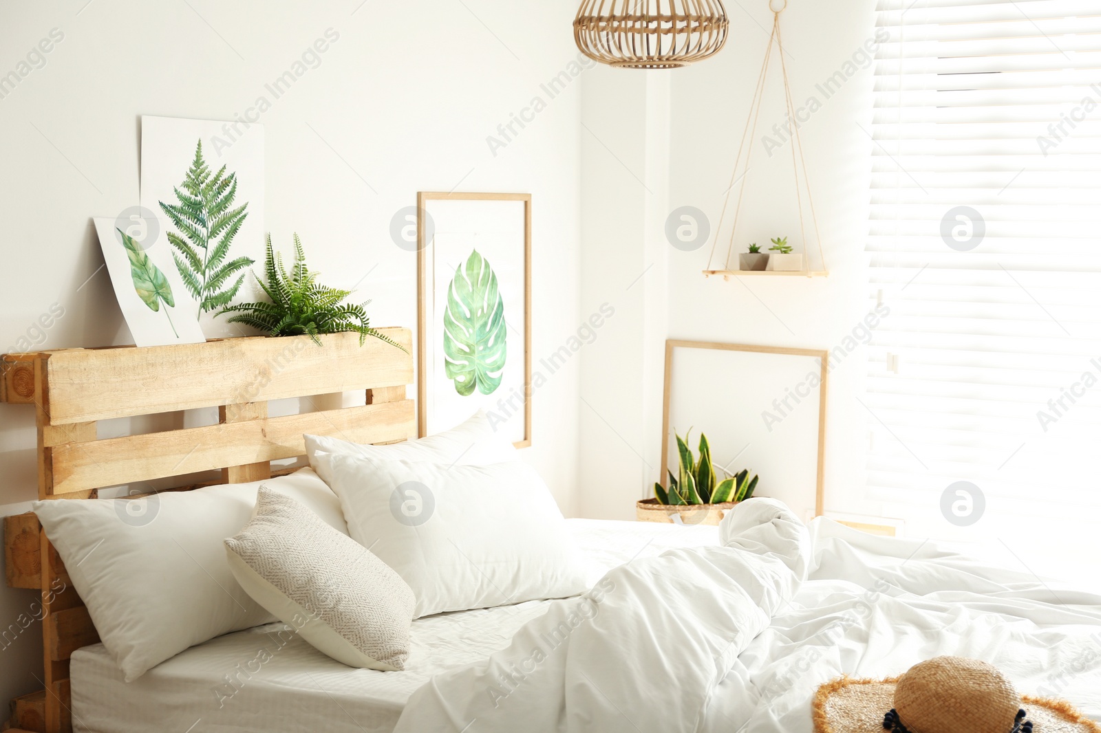 Photo of Stylish room interior with bed and floral pictures