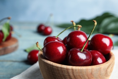 Photo of Wooden bowl with ripe sweet cherries on table, closeup. Space for text