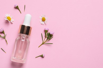 Photo of Bottle of cosmetic serum and beautiful flowers on pink background, flat lay. Space for text