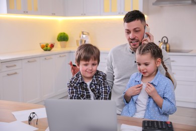 Photo of Multitasking man combining parenting and work at home