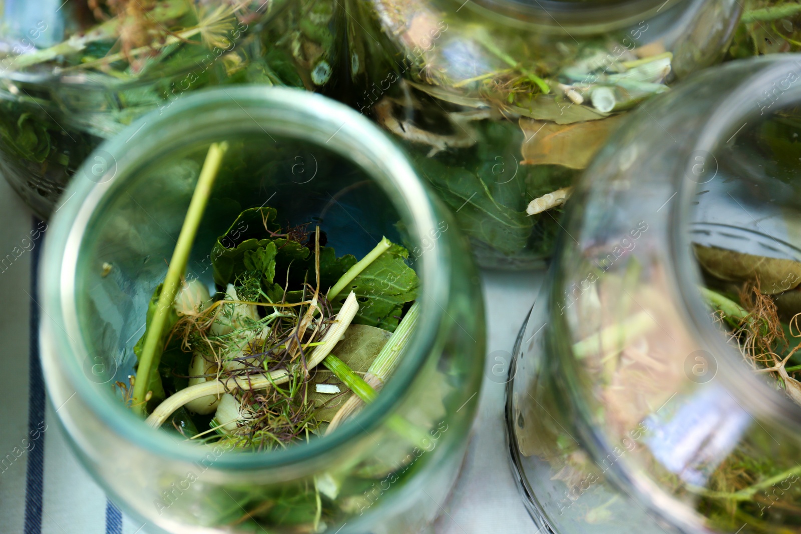 Photo of Glass jar with different herbs on table, above view. Pickling vegetables
