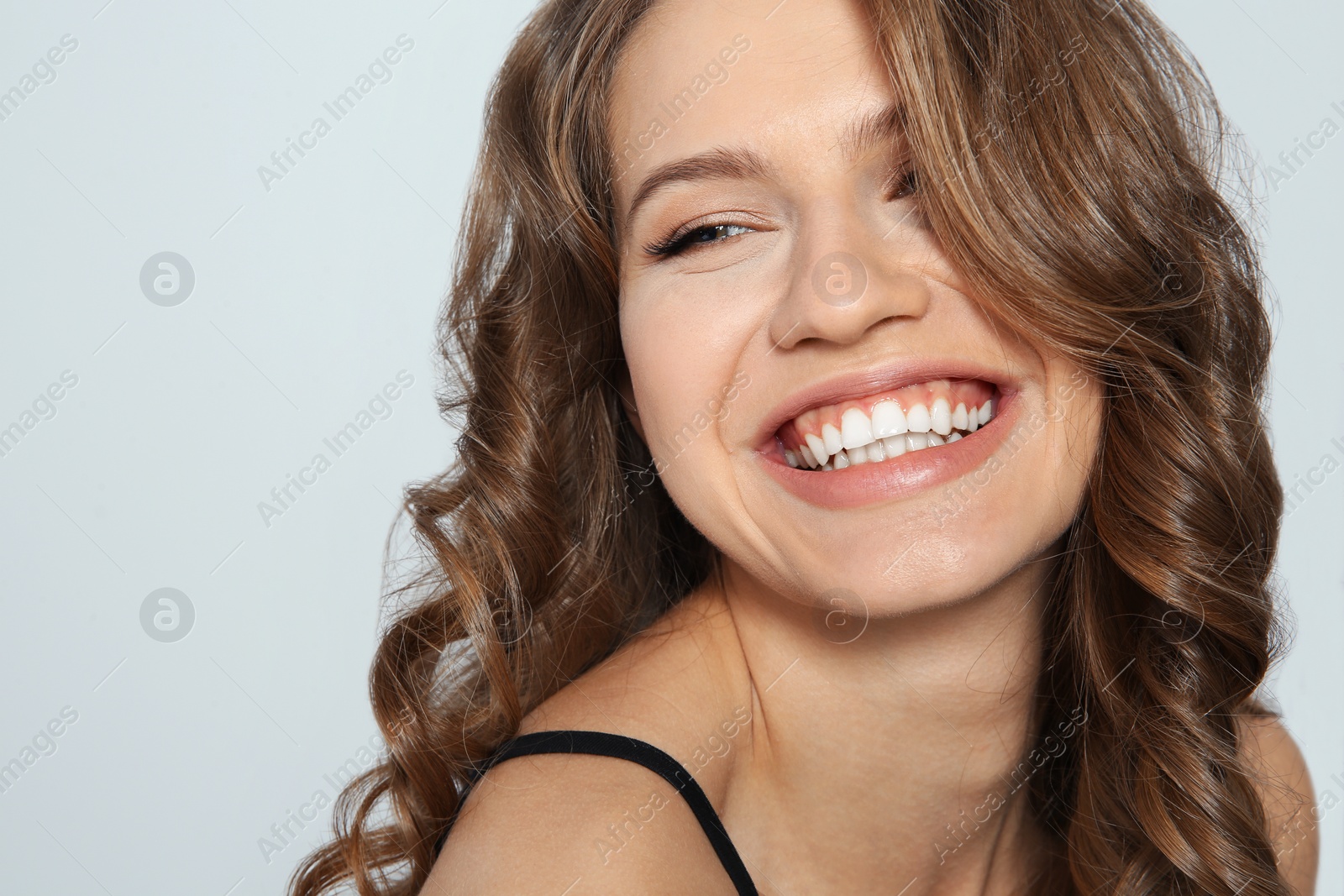 Photo of Portrait of beautiful young woman with shiny wavy hair on color background, closeup