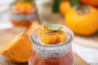 Delicious dessert with persimmon and chia seeds in jar, closeup