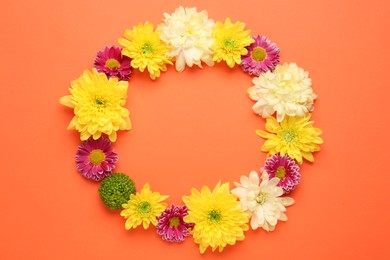 Photo of Frame made of beautiful chrysanthemum flowers on orange background, flat lay. Space for text