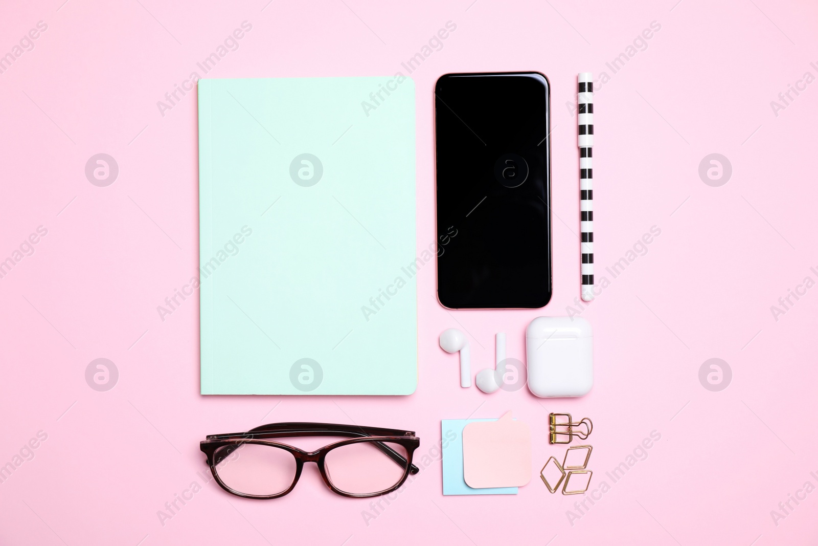 Photo of Flat lay composition with smartphone and stationery on pink background