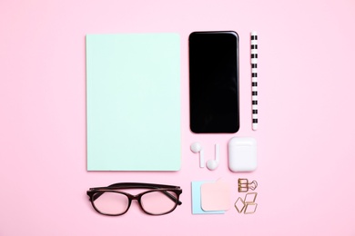 Photo of Flat lay composition with smartphone and stationery on pink background