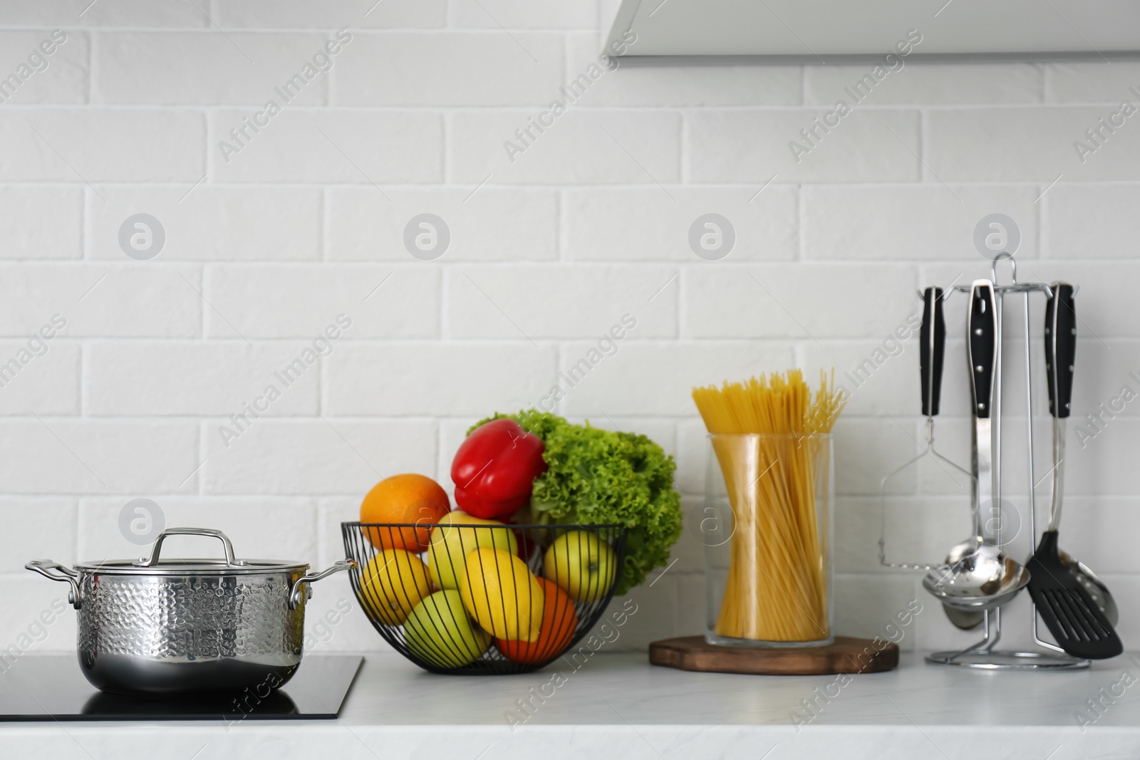 Photo of Kitchen counter with products, saucepot and utensils