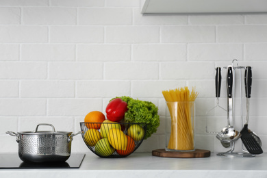 Photo of Kitchen counter with products, saucepot and utensils