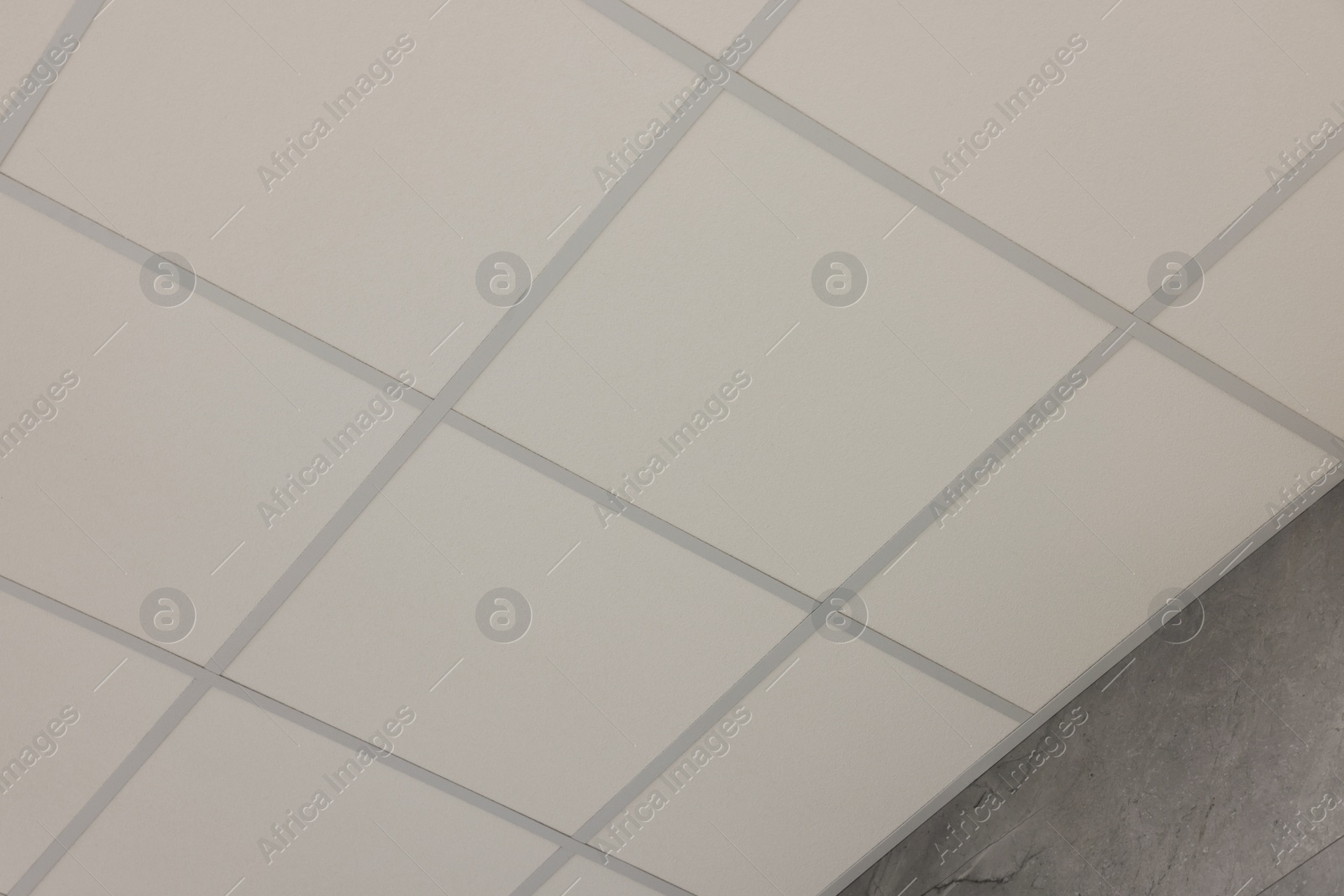 Photo of Light ceiling with PVC tiles, low angle view