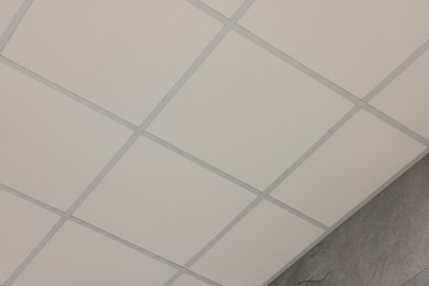 Photo of Light ceiling with PVC tiles, low angle view