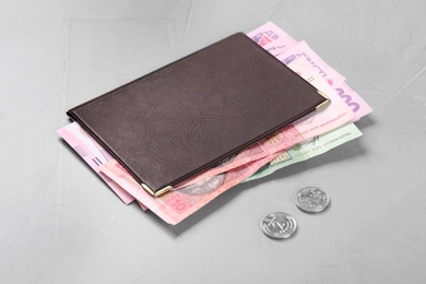 Photo of Pension certificate with Ukrainian money on grey stone background