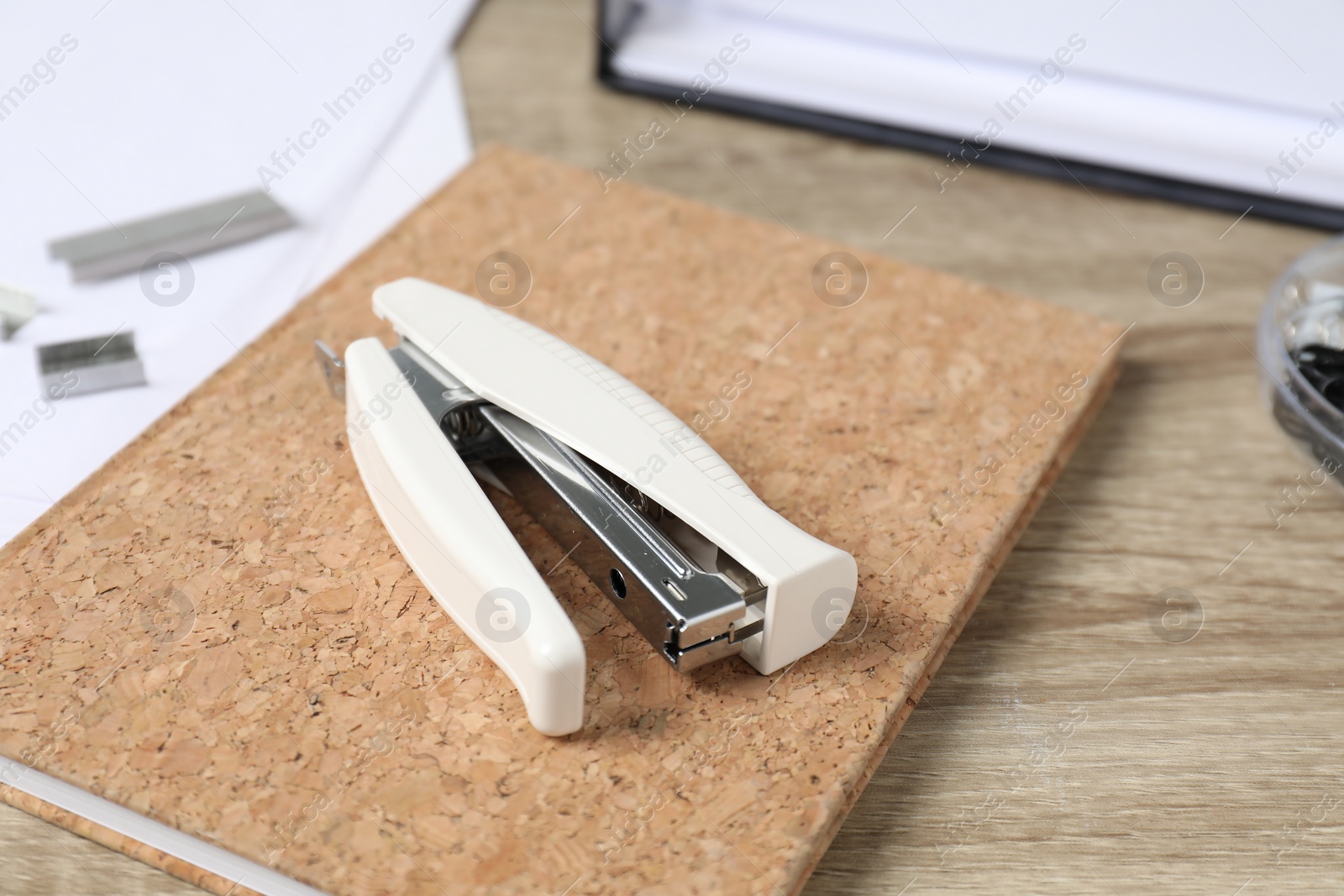 Photo of One stapler and notebook on wooden table