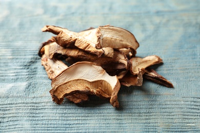 Photo of Delicious dried mushrooms on color wooden background, closeup