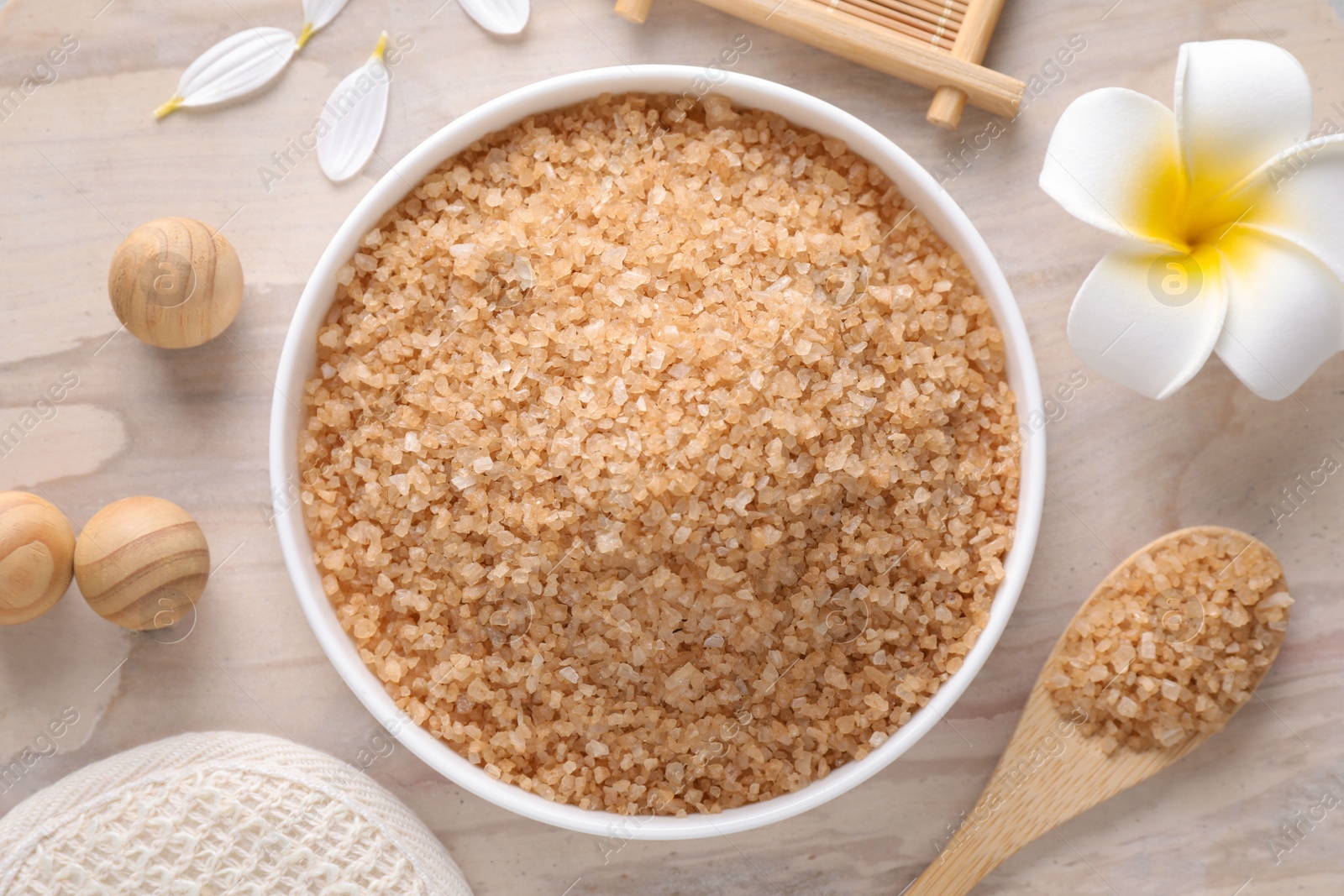 Photo of Flat lay composition with brown sea salt on wooden background. Spa treatment