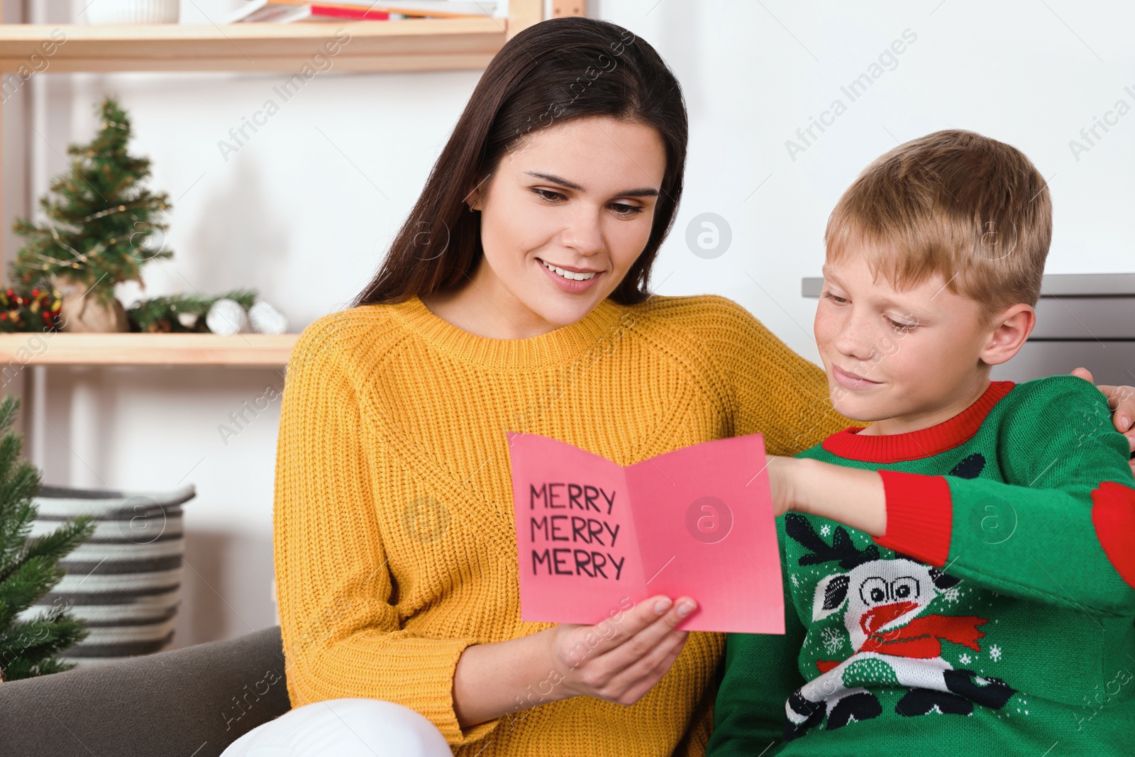 Photo of Happy woman receiving greeting card from her son at home