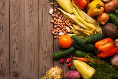 Photo of Different fresh vegetables on wooden table, flat lay with space for text. Farmer harvesting
