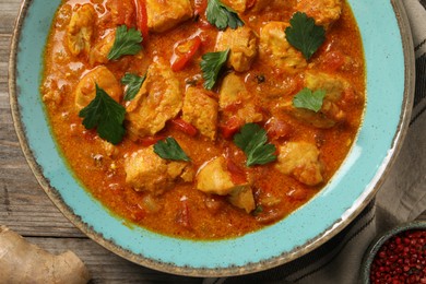 Delicious chicken curry on wooden table, top view