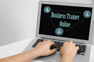 Image of Woman working with laptop at desk indoors, closeup. Business trainer online