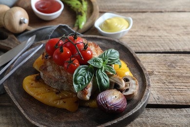 Photo of Delicious grilled meat and vegetables served on wooden table, closeup. Space for text