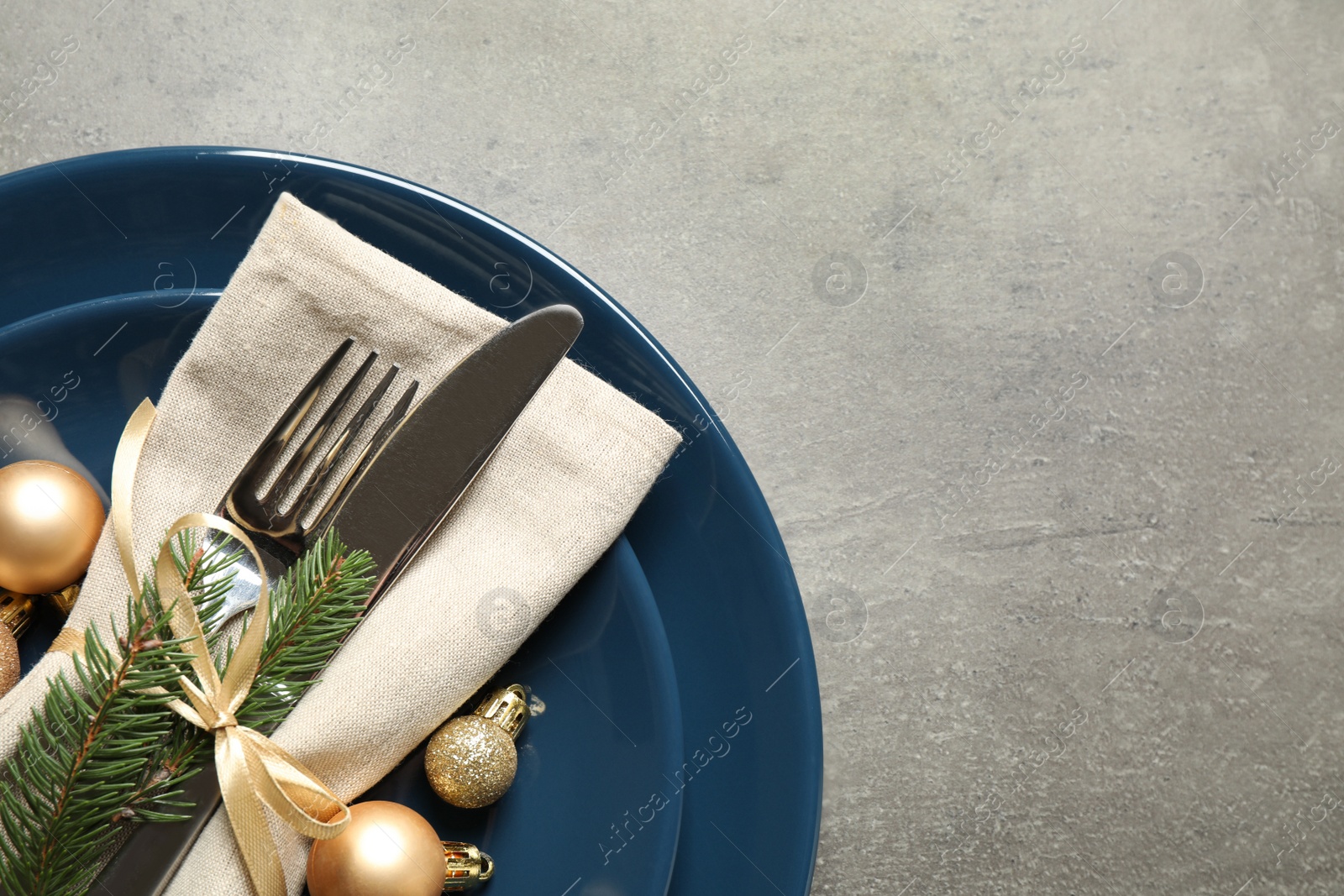 Photo of Festive table setting with beautiful dishware and Christmas decor on grey background, top view. Space for text