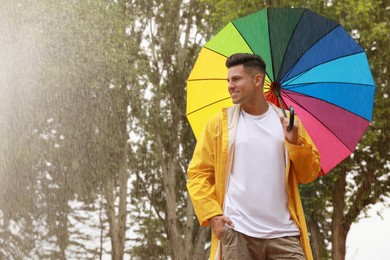 Man with umbrella walking under rain in park