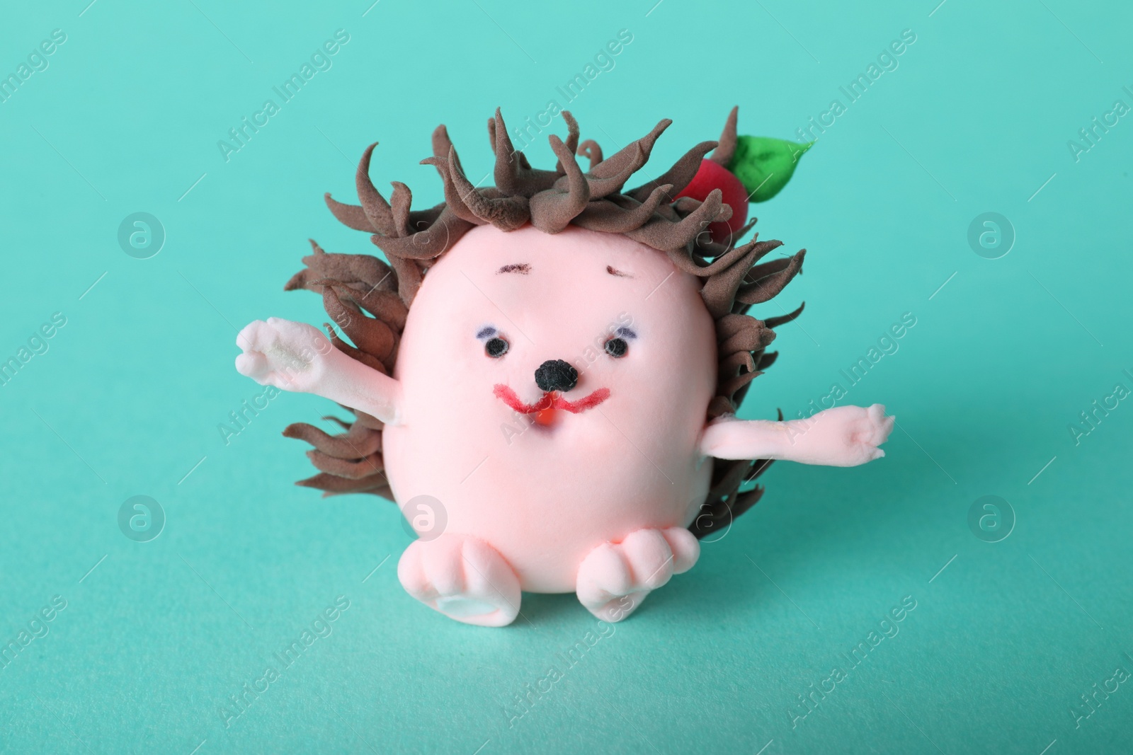 Photo of Small hedgehog made from play dough on turquoise background