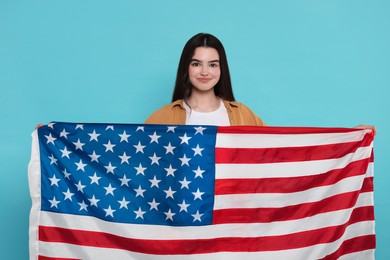 Photo of 4th of July - Independence Day of USA. Happy girl with American flag on light blue background