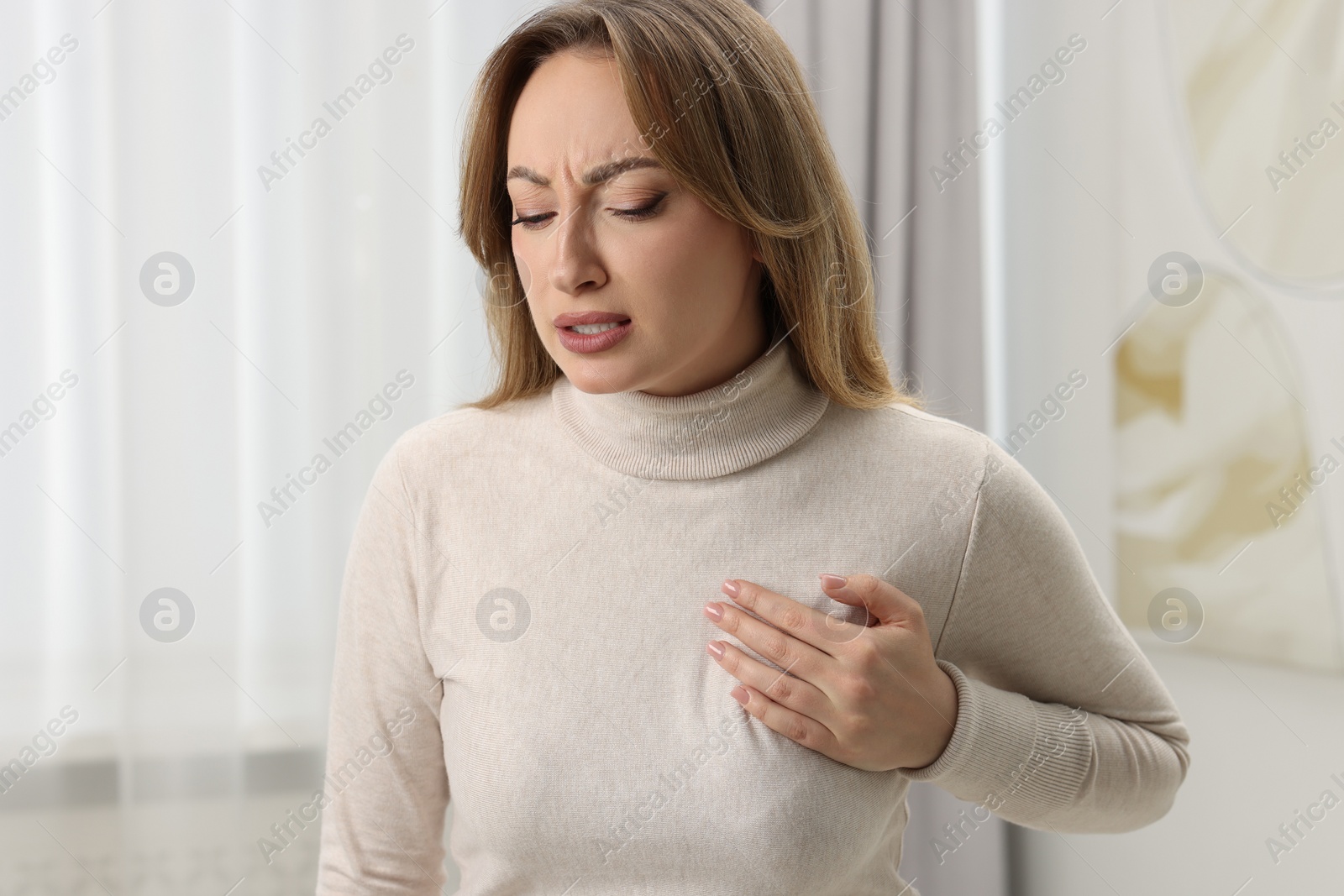 Photo of Mammology. Young woman doing breast self-examination at home