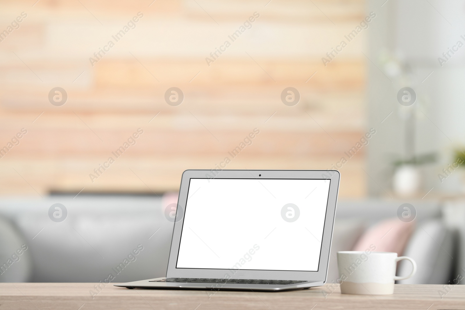 Photo of Laptop with blank screen on table indoors. Space for text