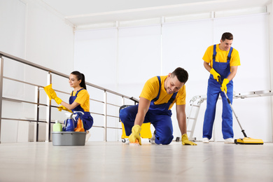 Team of professional janitors cleaning room after renovation