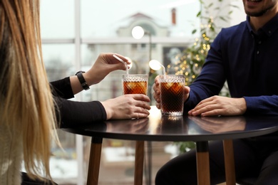 Photo of Couple with glasses of cold cola at table in cafe, closeup