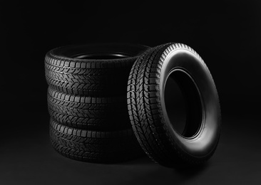 Photo of Set of winter tires on black background