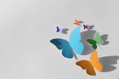 Image of Colorful bright paper butterflies on white wall