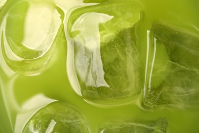 Photo of Delicious iced green matcha tea as background, closeup