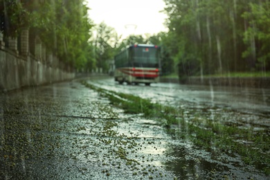 View of tram on city street under pouring rain