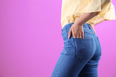 Photo of Woman in stylish blue jeans on color background