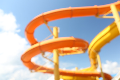 Photo of Different colorful slides in water park, blurred view