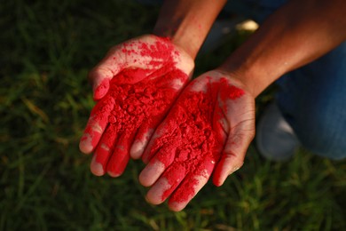 African American man with red powder dye outdoors, closeup. Holi festival celebration