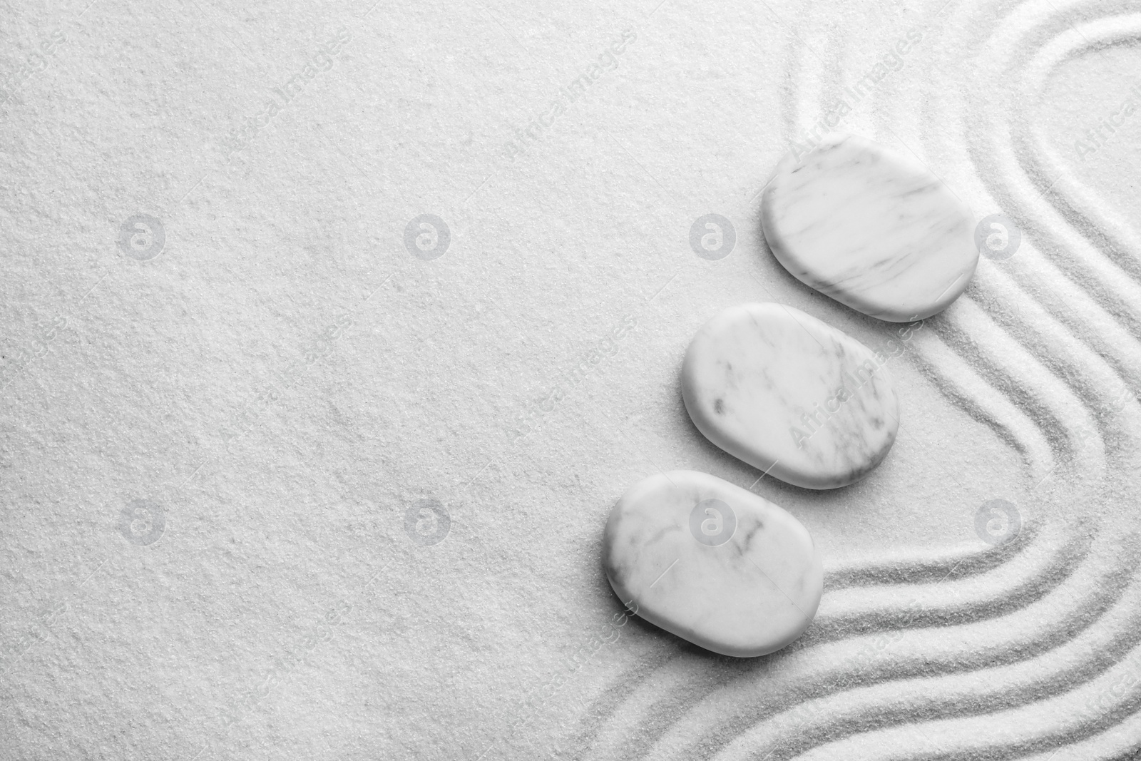 Photo of Top view of white stones on sand with pattern, space for text. Zen, meditation, harmony