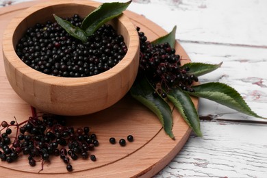 Tasty elderberries (Sambucus) on white wooden table