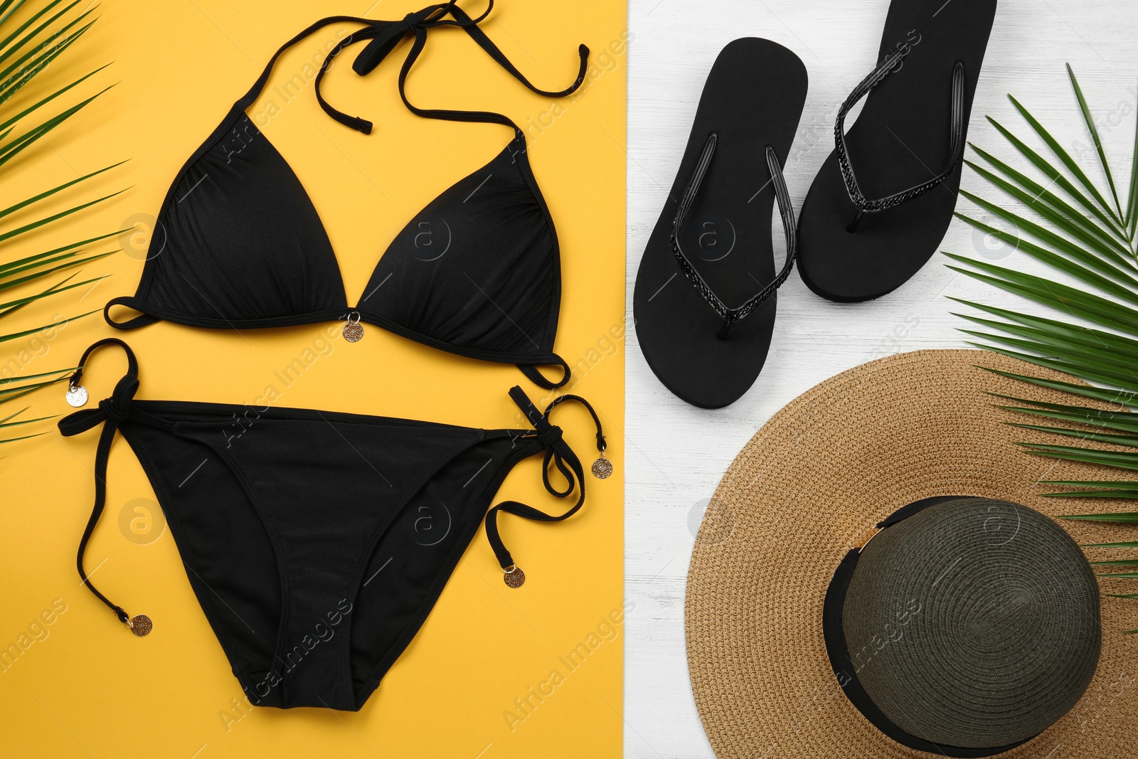 Photo of Flat lay composition with black swimsuit and beach accessories on color background