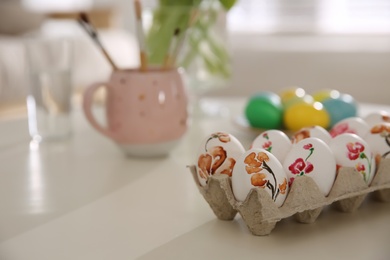 Beautifully painted Easter eggs on white table indoors, space for text