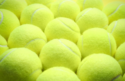 Tennis balls as background, closeup. Sports equipment